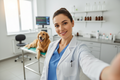 A female veterinarian taking a selfie, keeping a professional pose
